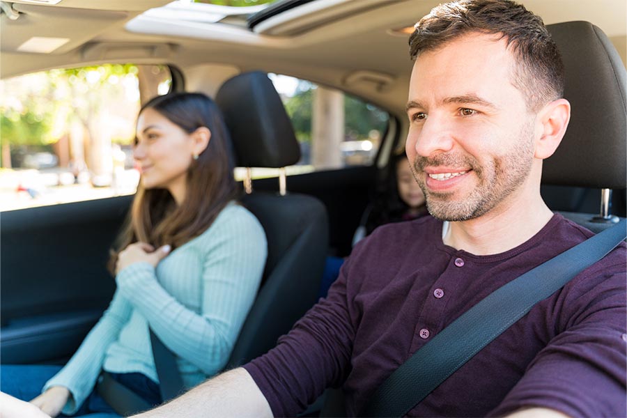 Personal Insurance - A Couple Driving in Their Car, Young Daughter in the Backseat, Husband at the Wheel