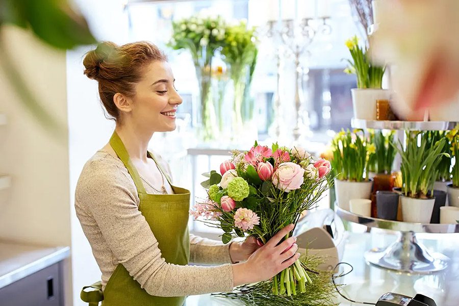 Floral Shop Insurance - Smiling Florist Arranging a Bouquet at a Flower Shop